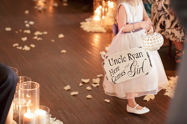 Flower girl carries a sign for the groom.