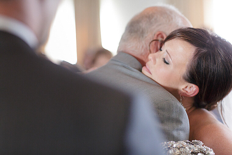 Bride and father hug at the altar.