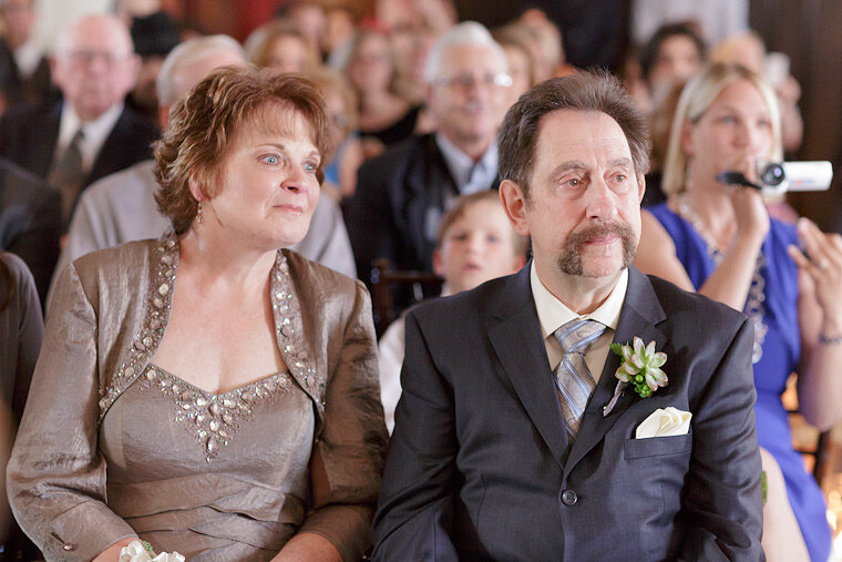 Groom's parents watch the ring exchange.