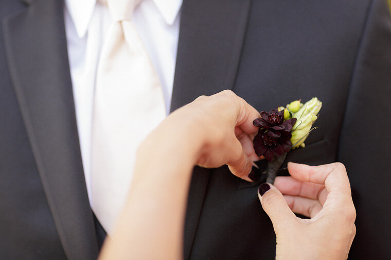 Christy Daly pins boutonniere on groomsmen.