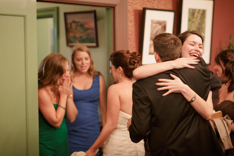 Bride and groom hug friends after being married.