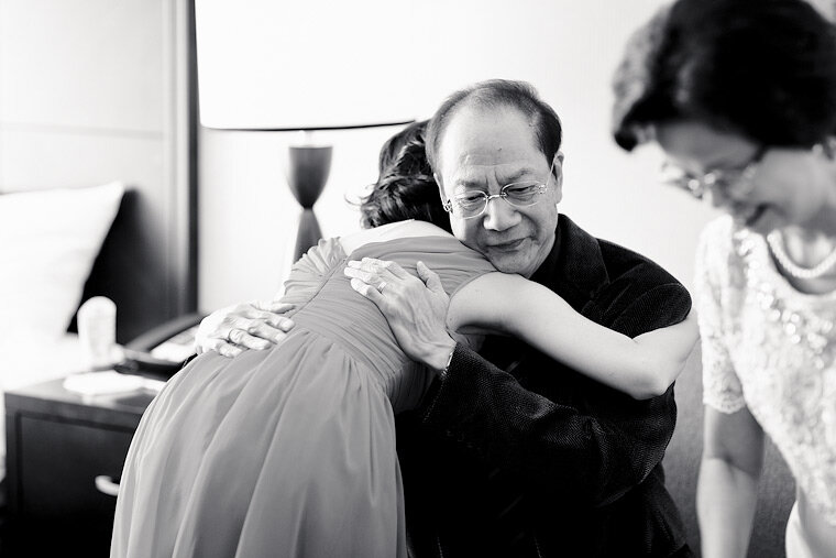 Bride hugs father after a small Chinese tea ceremony.