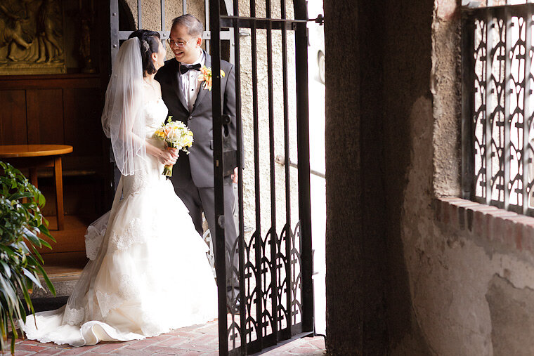 Bride and groom smile together in the front gate of the Swedenborgian Church.