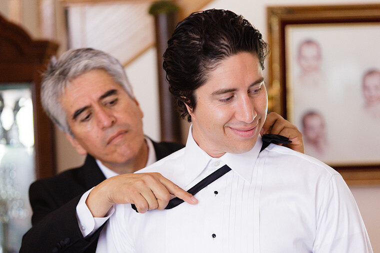 Groom's father helps with the bowtie.