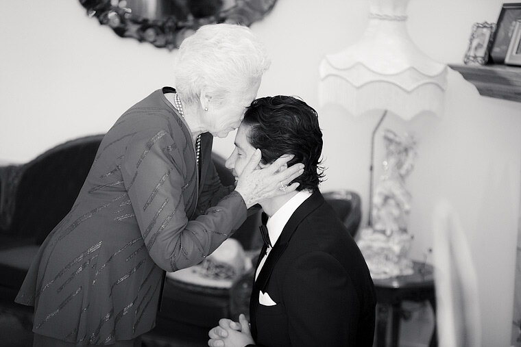 Grandmother kisses groom before wedding.
