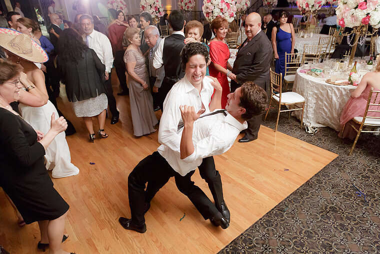 Groom dances with friend at reception.