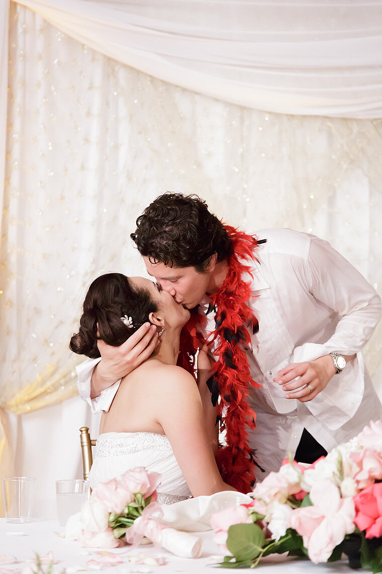 Bride and groom kissing at reception.
