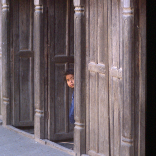 A boy looking out from many doors
