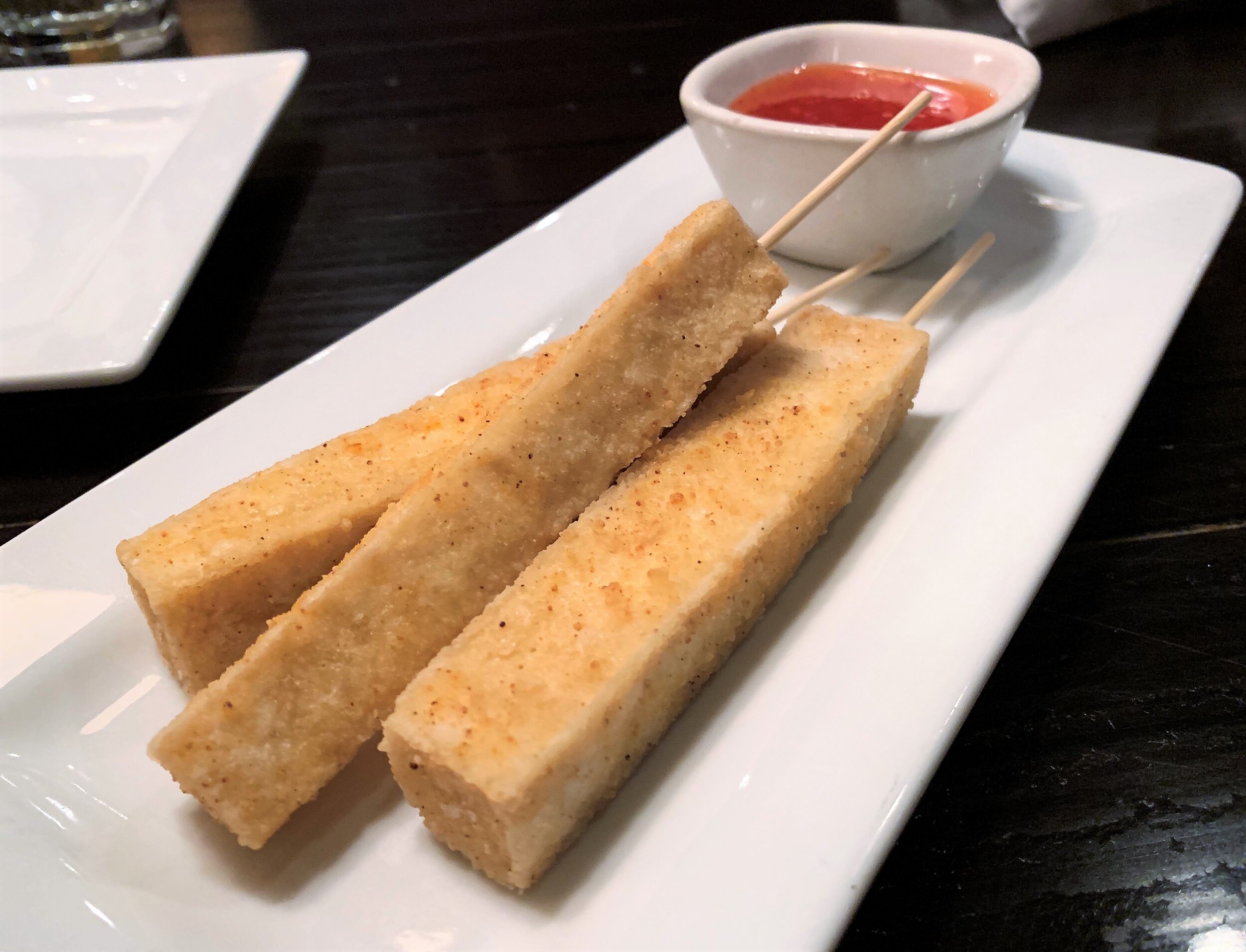 Three sticks of fried tofu with sweet chili sauce at Ginger Hop in northeast Minneapolis