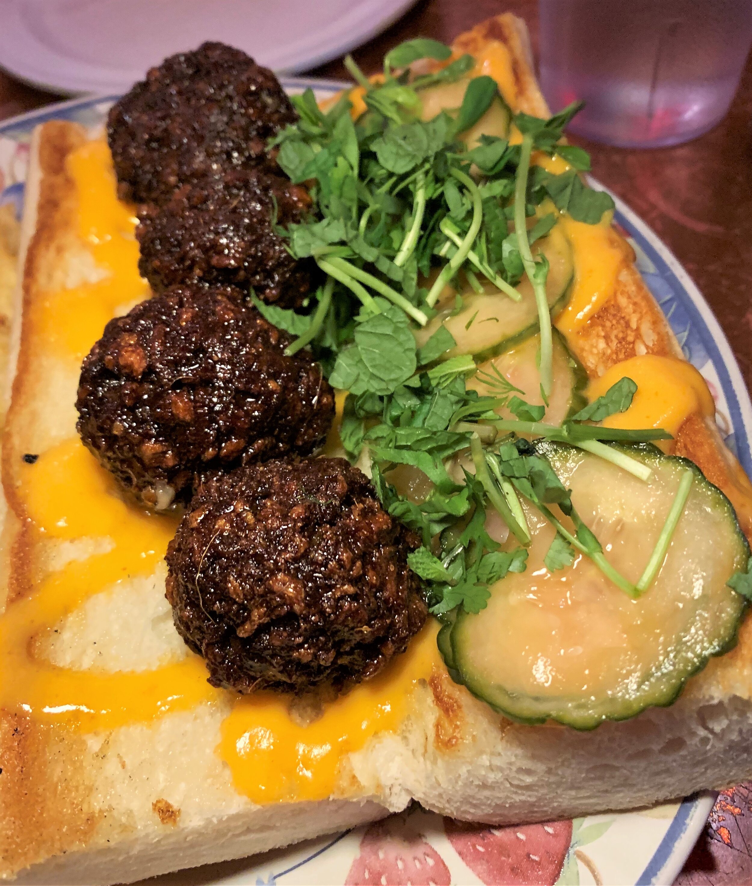 A banh mi sandwich with plant based meatballs using Impossible Foods burgers, plus mayo and pickles at Bar Luchador's I Can't Believe It's Vegan night.