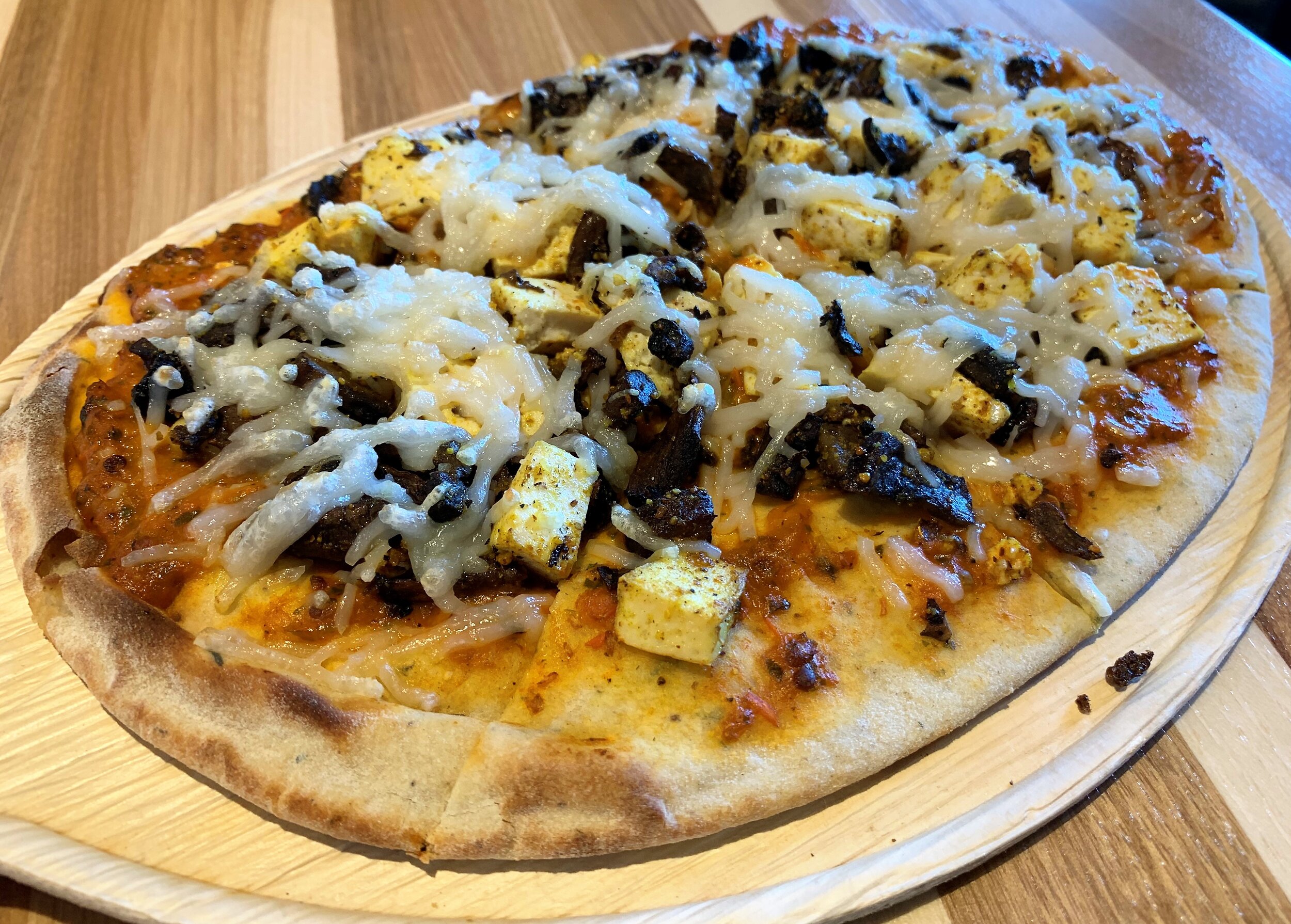 pizza karma build your own vegan pizza with harissa sauce, seasoned tofu, wild mushrooms, and Daiya cheese