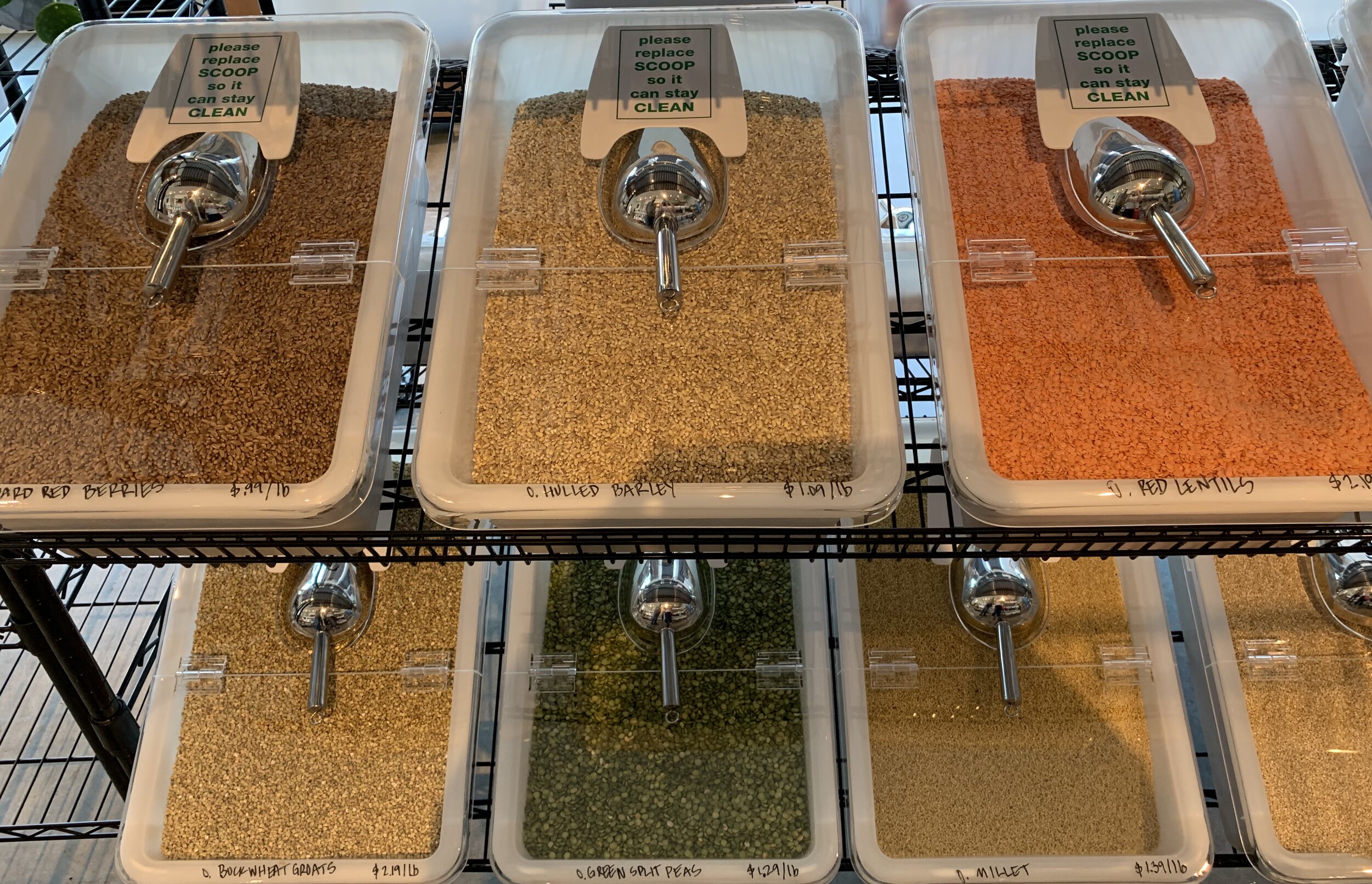 bulk bins including hulled barley, red lentils, buckwheat groats, green split peas, and millet