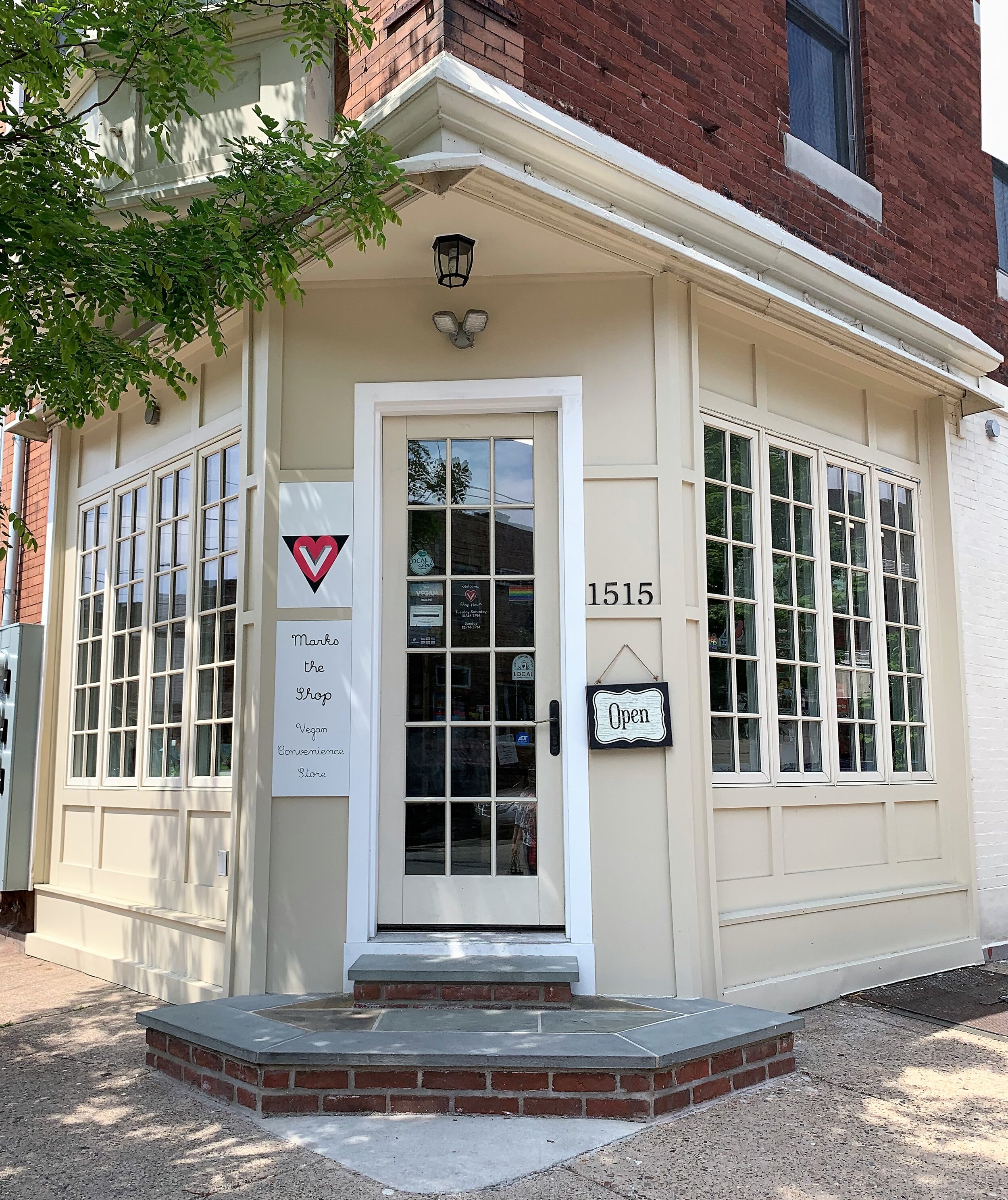 storefront of V Marks the Shop in Philadelphia with an Open sign hanging by the door