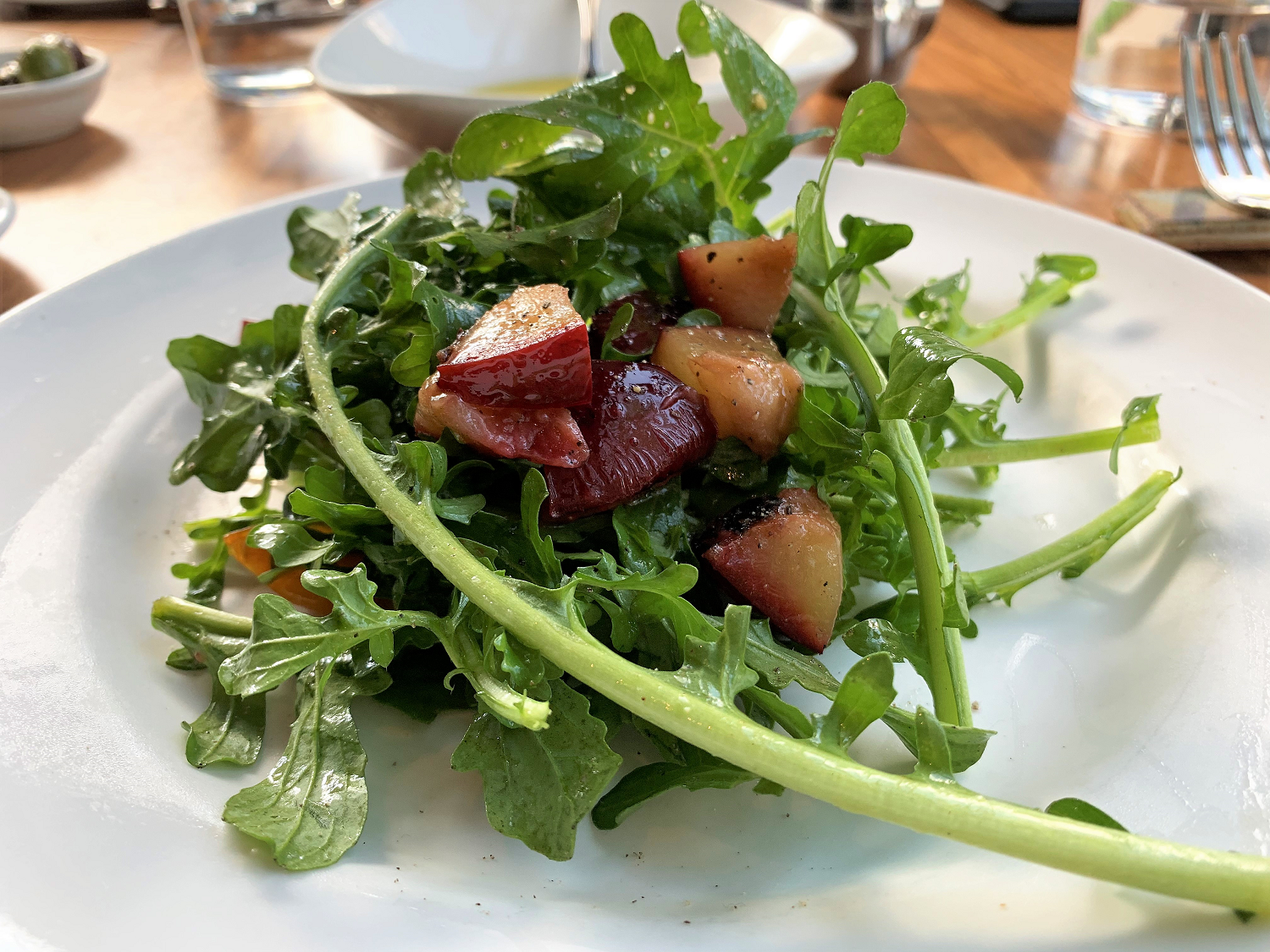 plate of arugula topped with grilled plums