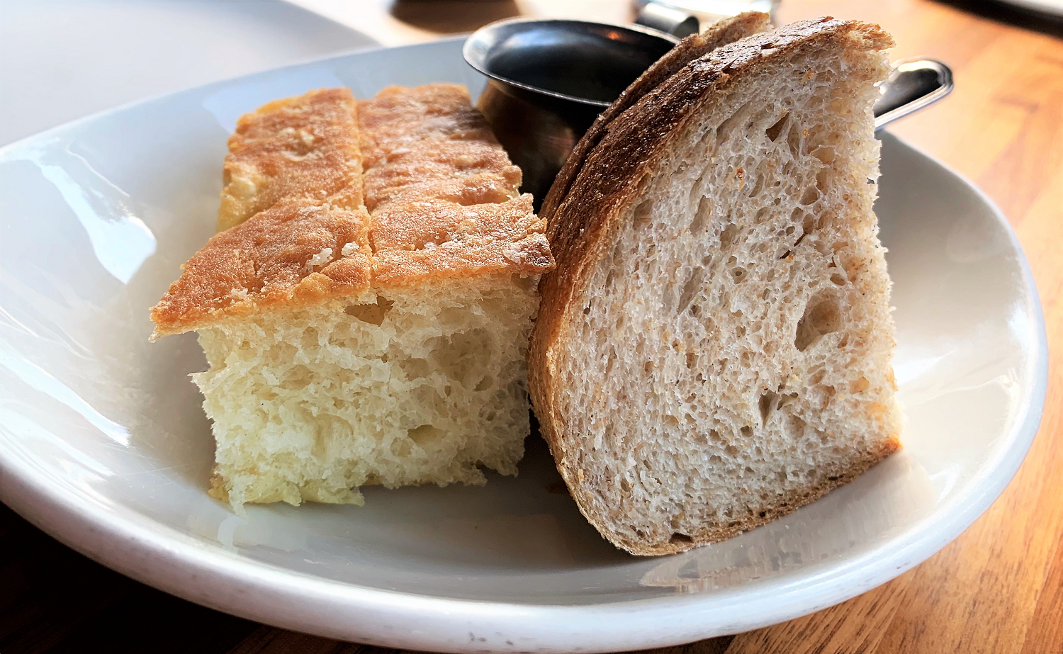 a plate with lighter focaccia bread and darker sourdough bread