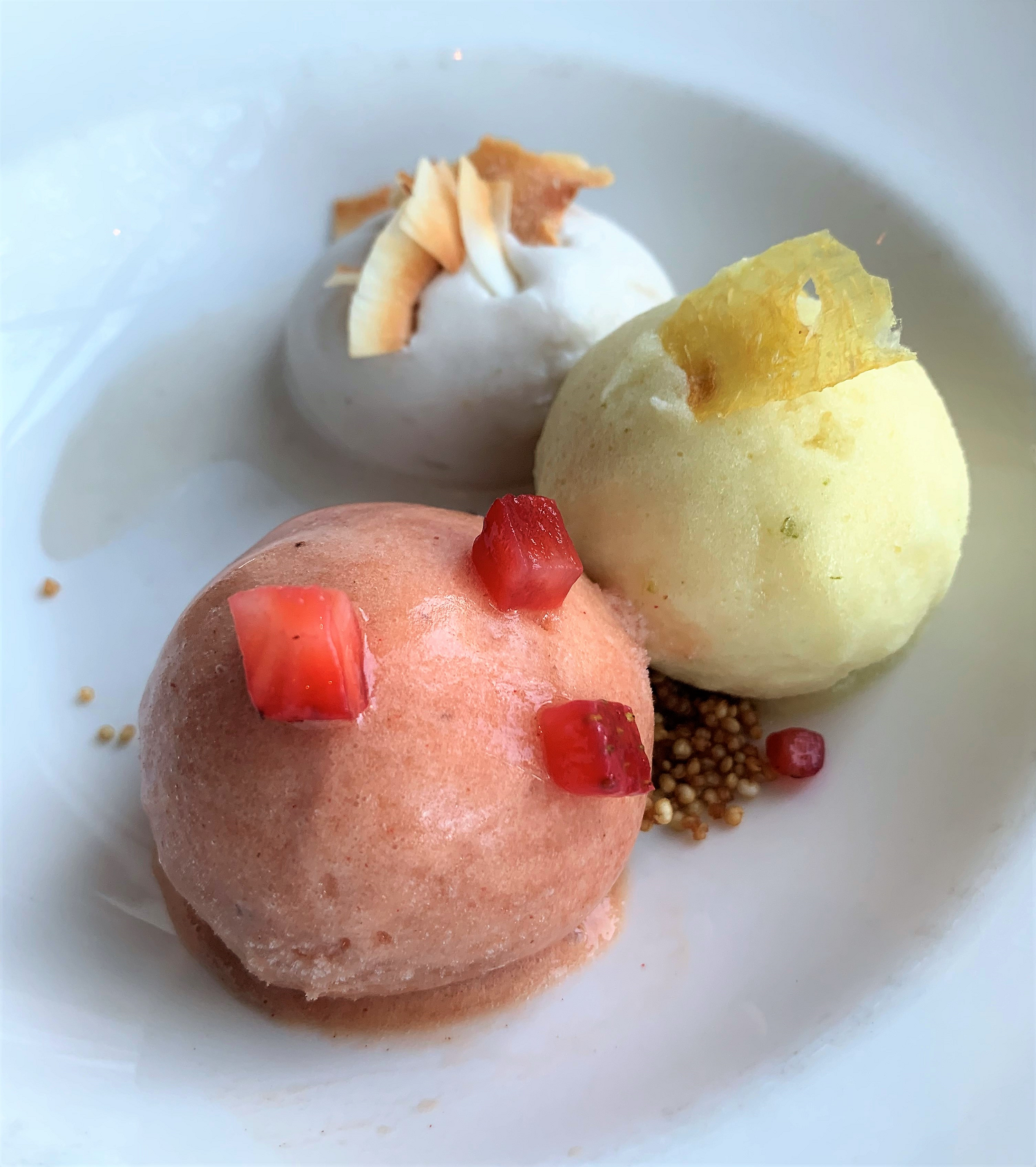 three scoops of sorbet that are pink, yellow, and white