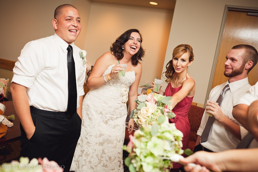 bride and groom laughing with bridal party