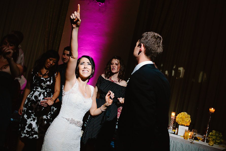 bride and groom dancing with fuchsia uplighting