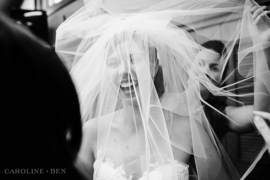 bride laughing under veil before wedding