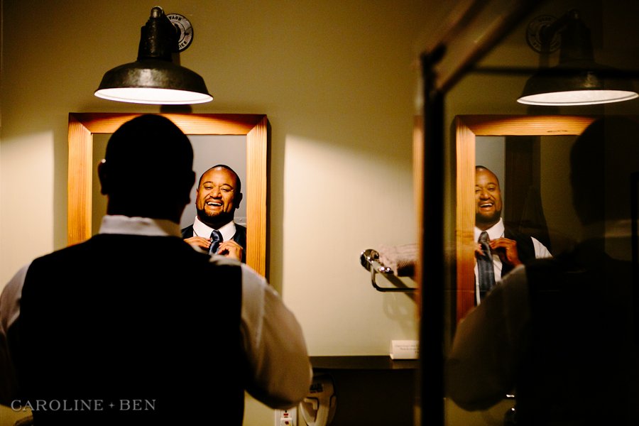 groom getting ready in mirror