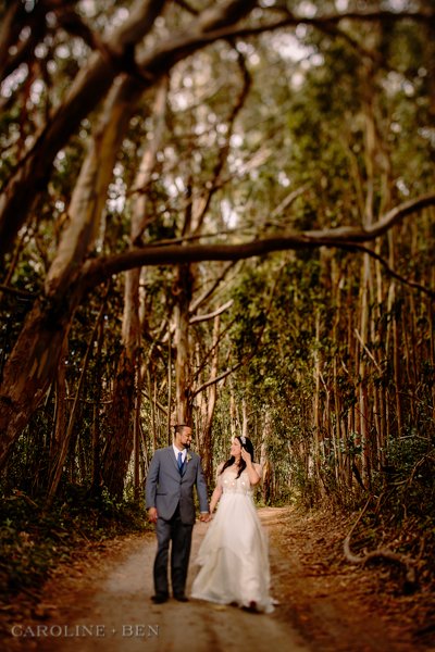 bride and groom walking through tall trees