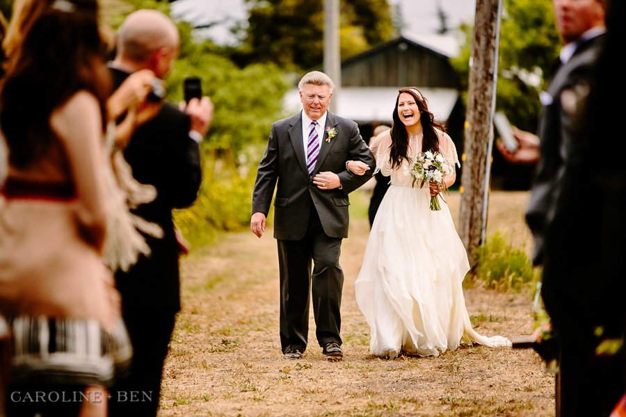 father and bride walking down aisle of outdoor ceremony