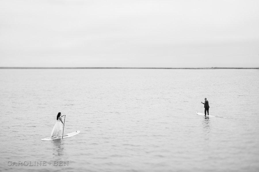 bride and groom on paddle boards