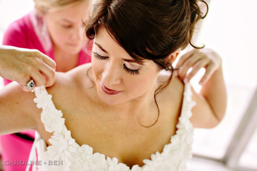 beautiful bride putting on the dress before the wedding ceremony