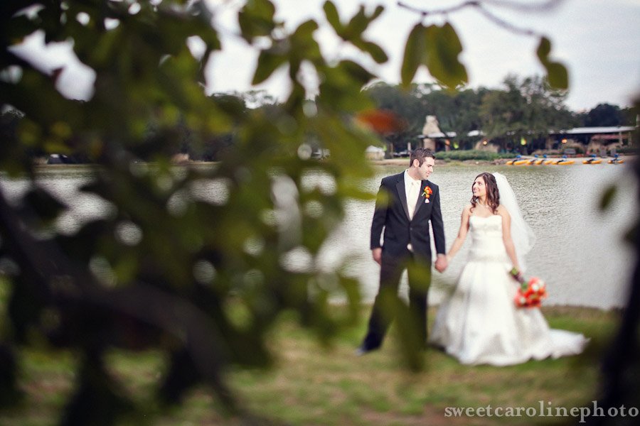 bride and groom holding hands by lake at Country Club