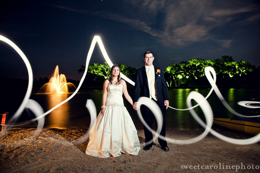 bride and groom long exposure light painting next to fountain