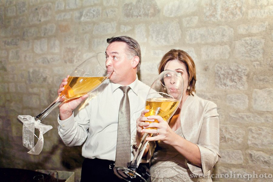 father and mother of groom drinking out of huge wine glasses