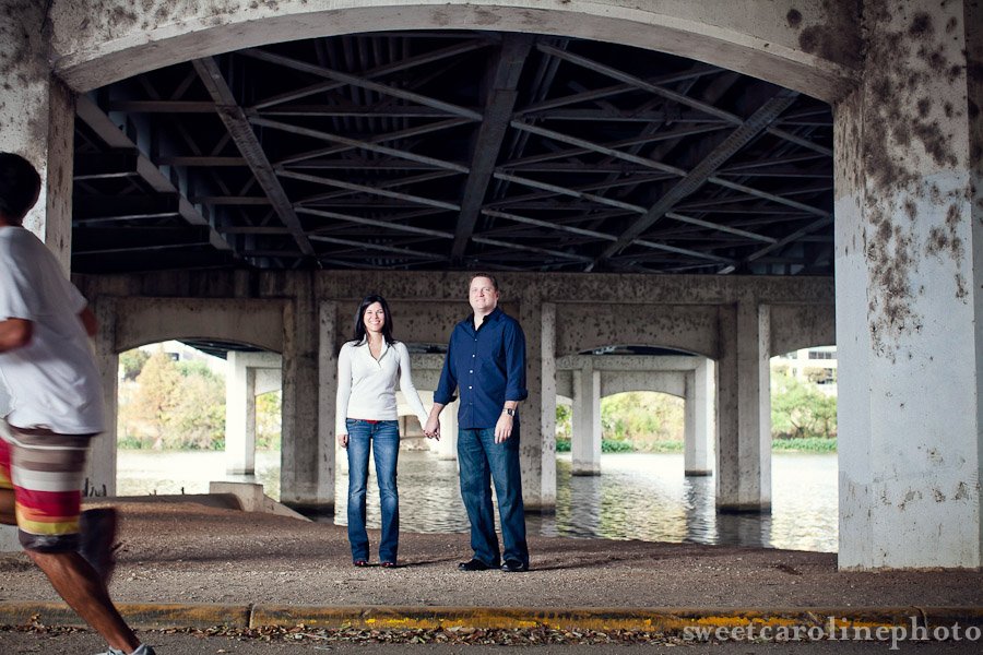 couple standing under first street bridge in Austin