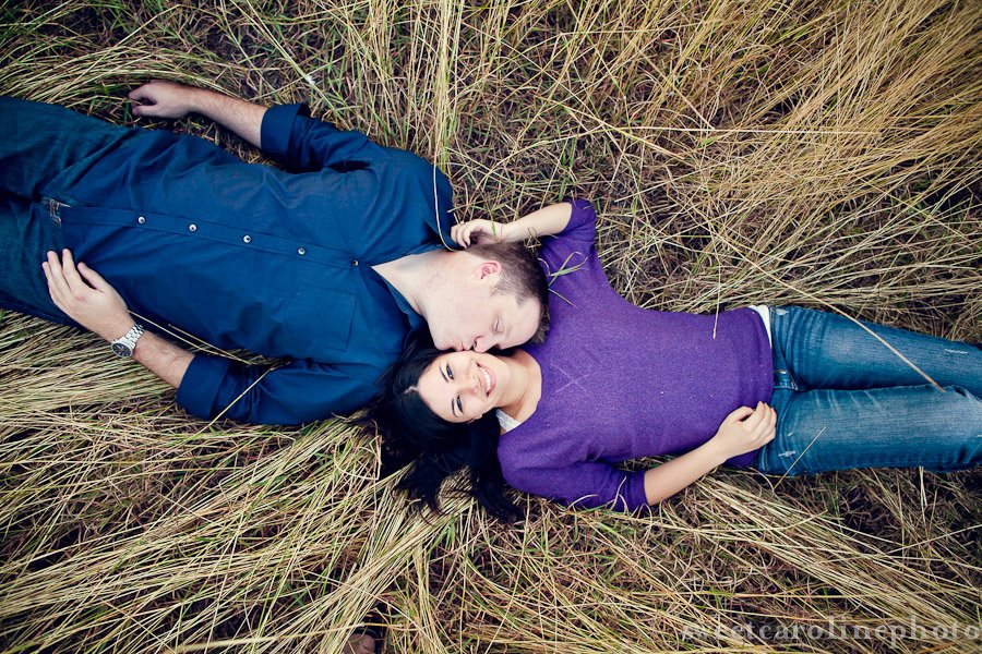 couple laying by each other in field