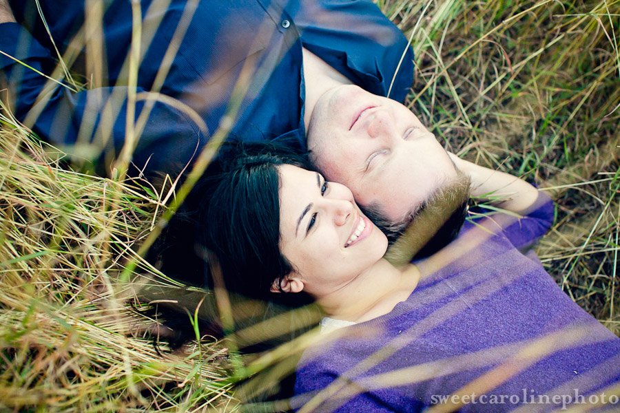 couple laying together in field by Austin wedding photographer