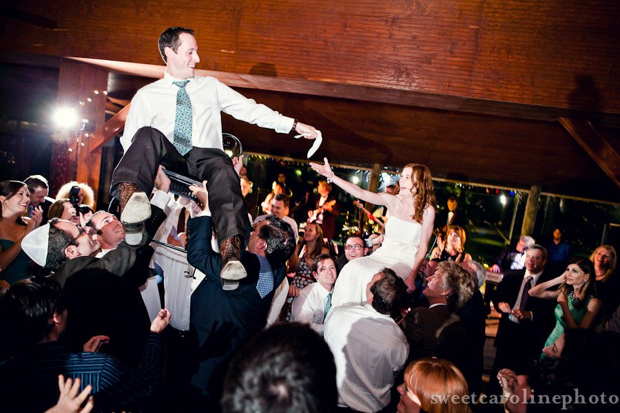 Jewish bride and groom being lifted in chairs during reception at Salt Lick Pavilion
