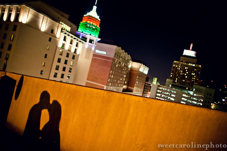 bride and groom's kissing shadow with San Antonio night skyline