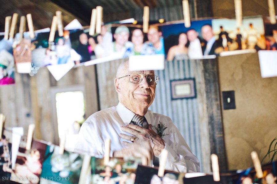 grandpa looking at photographs hanging on clothesline