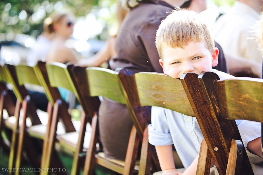 kid leaning on chair during vista west ranch wedding ceremony