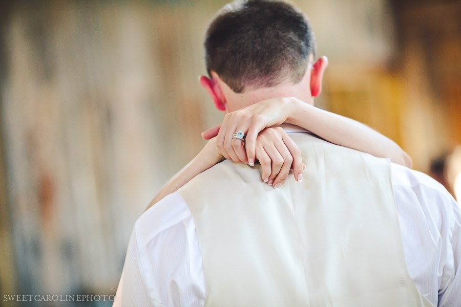 bride's hands with blue engagement ring during first dance