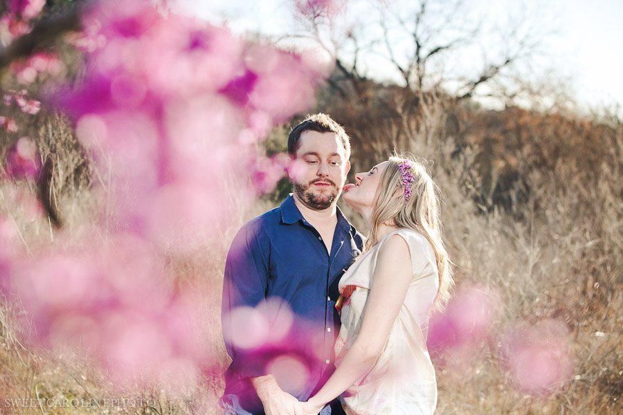 couple licking shot through pink flowers