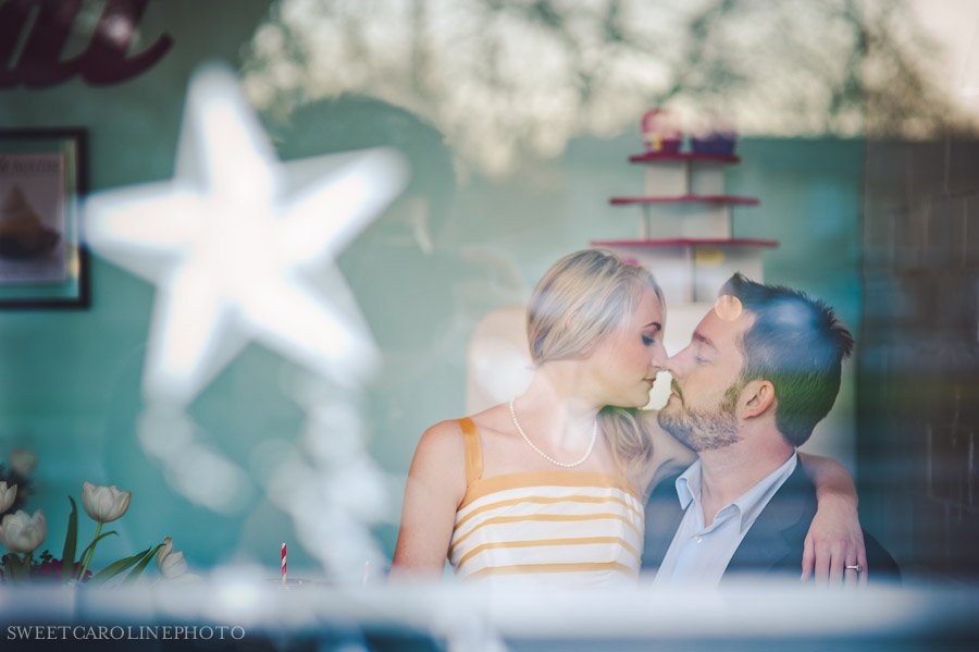 couple kissing shot through storefront window