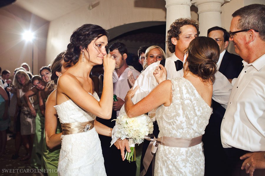 bride crying as she exits the wedding reception