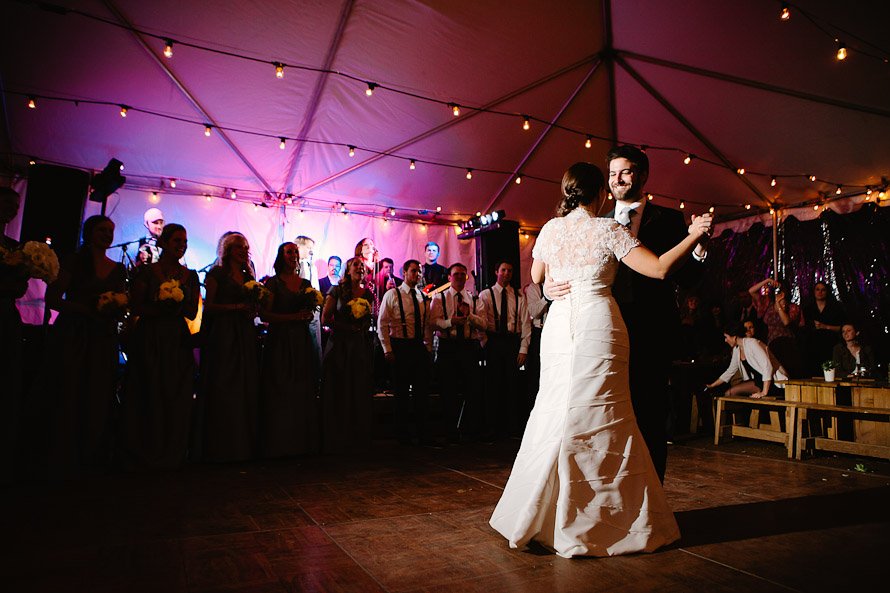 bride and groom first dance in tent with purple uplighting
