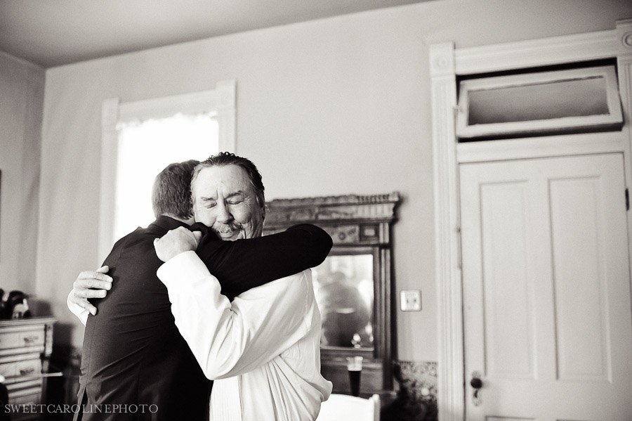 father of bride and groom hugging