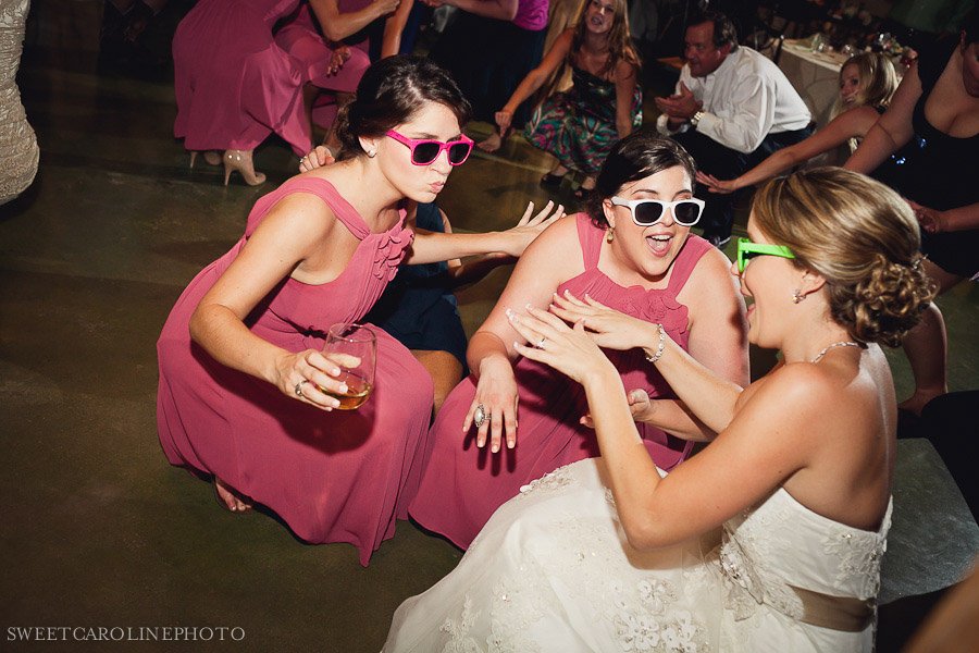 bride and bridesmaids in sunglasses on dance floor