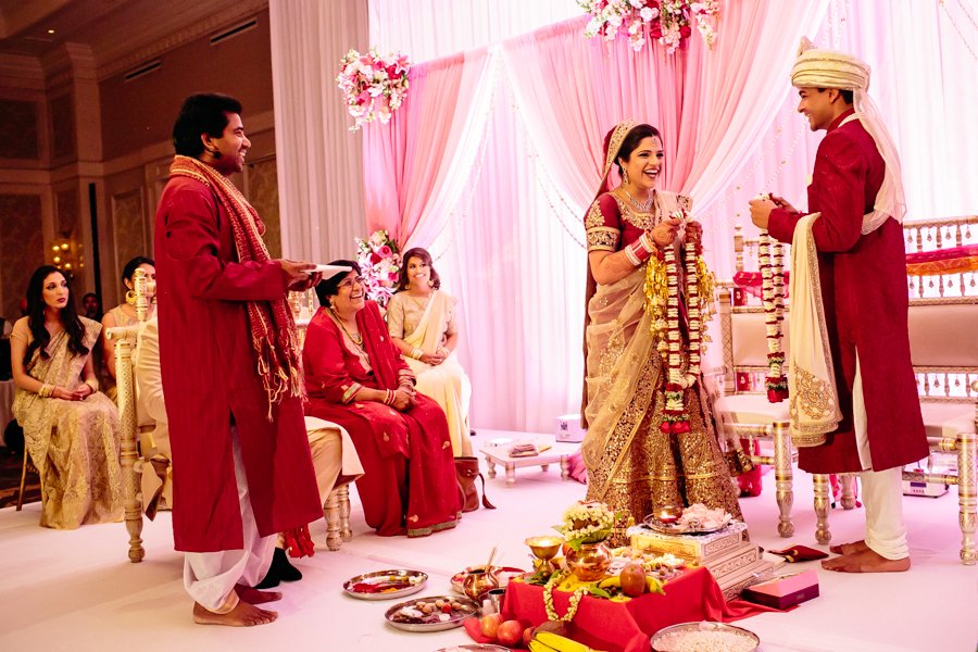 bride and groom exchanging garlands in hindu ceremony