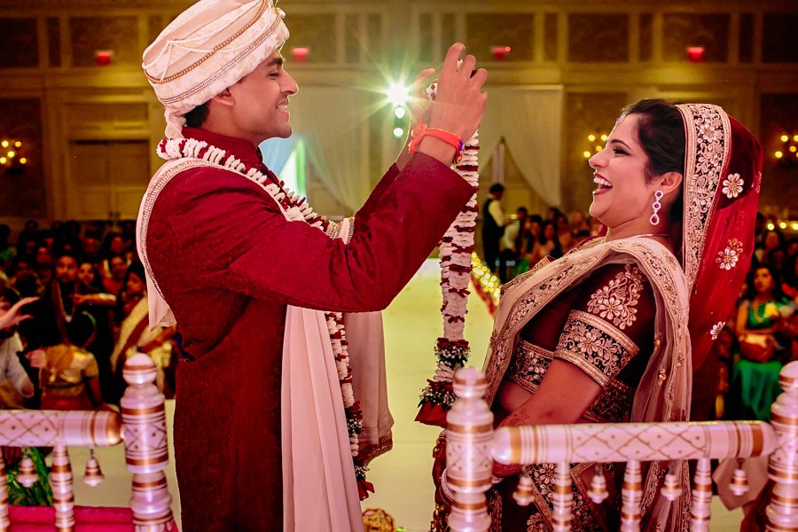bride and groom exchanging garlands in hindu ceremony