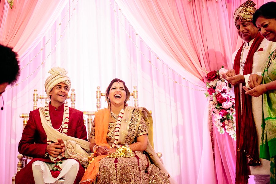 bride and groom laughing during hindu ceremony