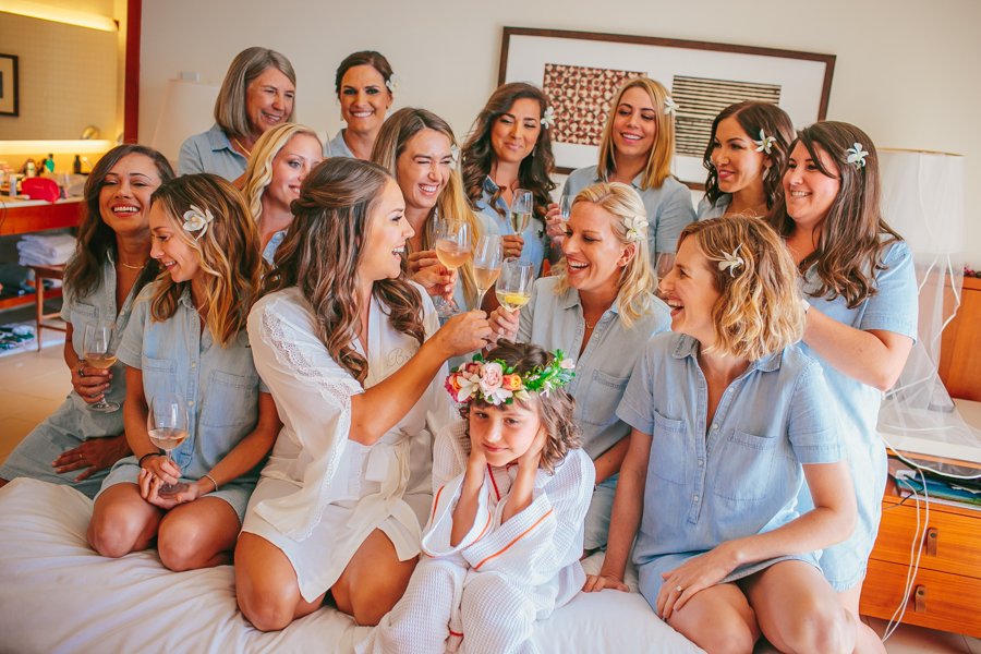 bride and bridesmaids toasting on bed