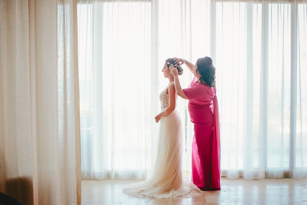 mother of bride helping put dress on